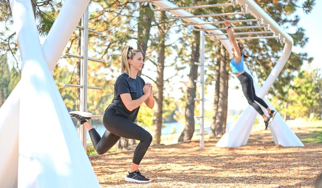 two people working out on an outdoor fitness structure