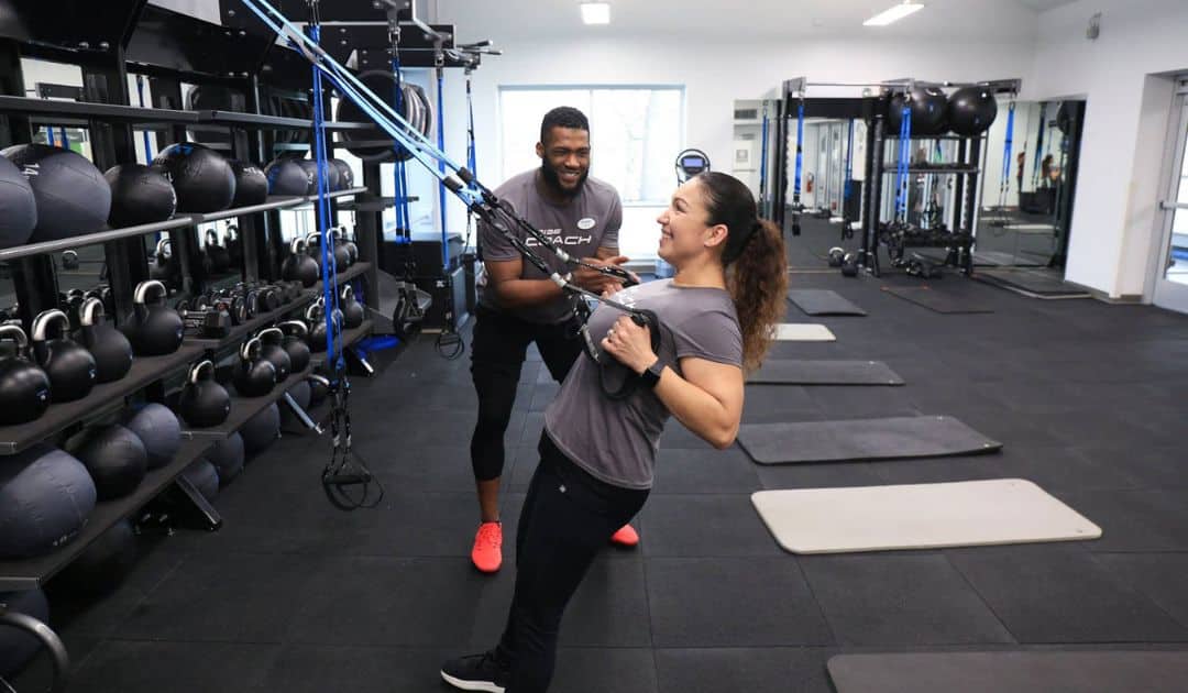 A Tribe Coach giving instructions to a fitness member. 