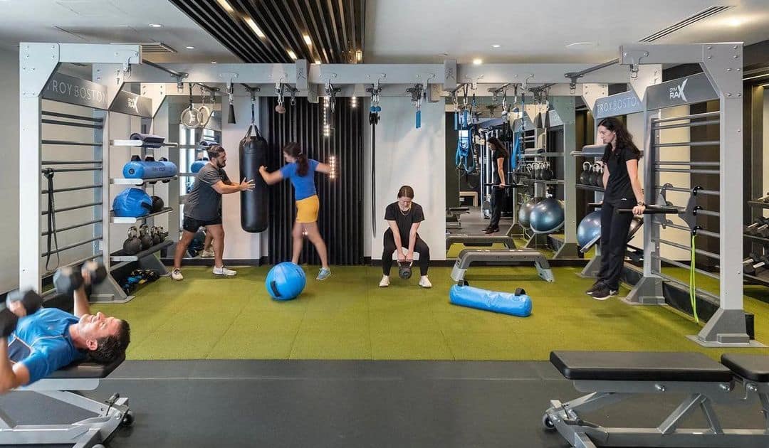 Group of people working out in a fitness facility designed with the psychology of gym design. 