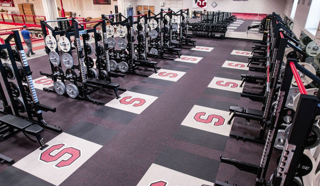 High school weight room designed with custom equipment branding. 