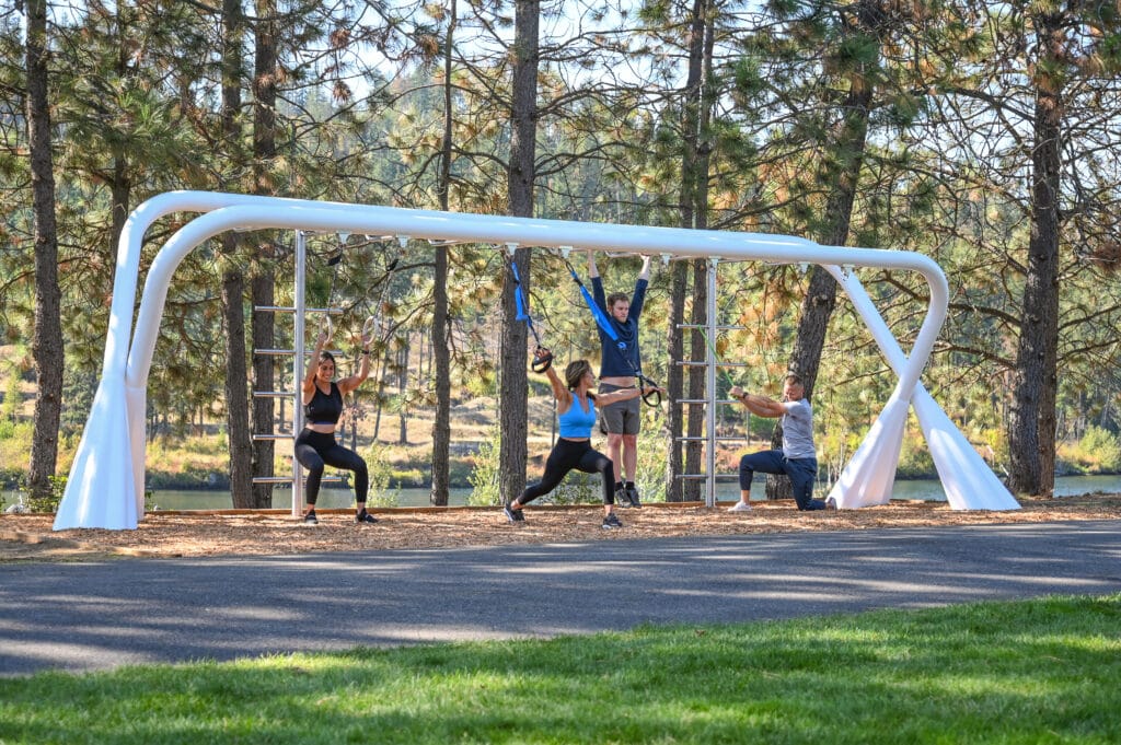 Group of people working out on Ecosytem outdoor gym equipment.