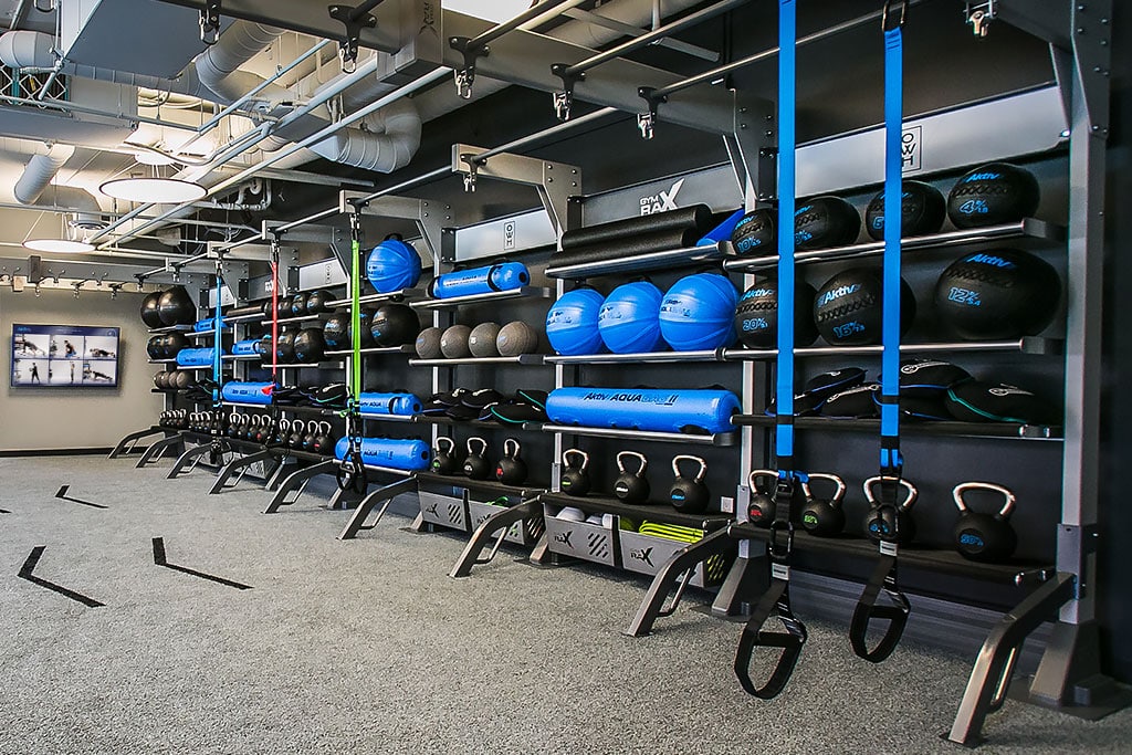 Two squat racks and a free weight strength training area with dumbbells and two benches.